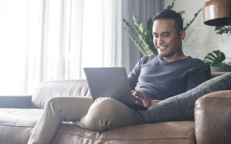 Man sitting on couch with laptop