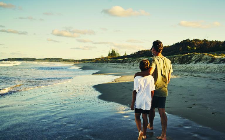 Father and son walking along the beach