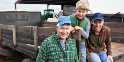 Grandfather, father and son smiling on a farming truck
