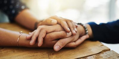 Female hands holding another person's hands for support