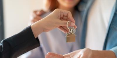 Person handing over property keys to couple