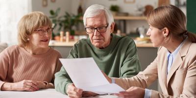 Older woman and man looking at document with younger woman